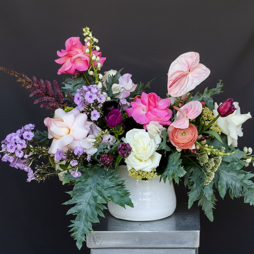 Floral arrangement in a white vase against a pink background designed in Austin, TX