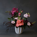Floral arrangement in a white vase on a wooden surface delivered in austin tx