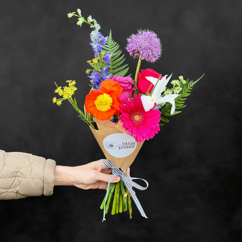 Austin TX local Bouquet of colorful flowers held by a person against a black background