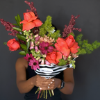 Bouquet of colorful flowers held by a person against a dark background delivery in austin tx