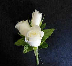 White rose boutonniere on a dark background created by posey floral